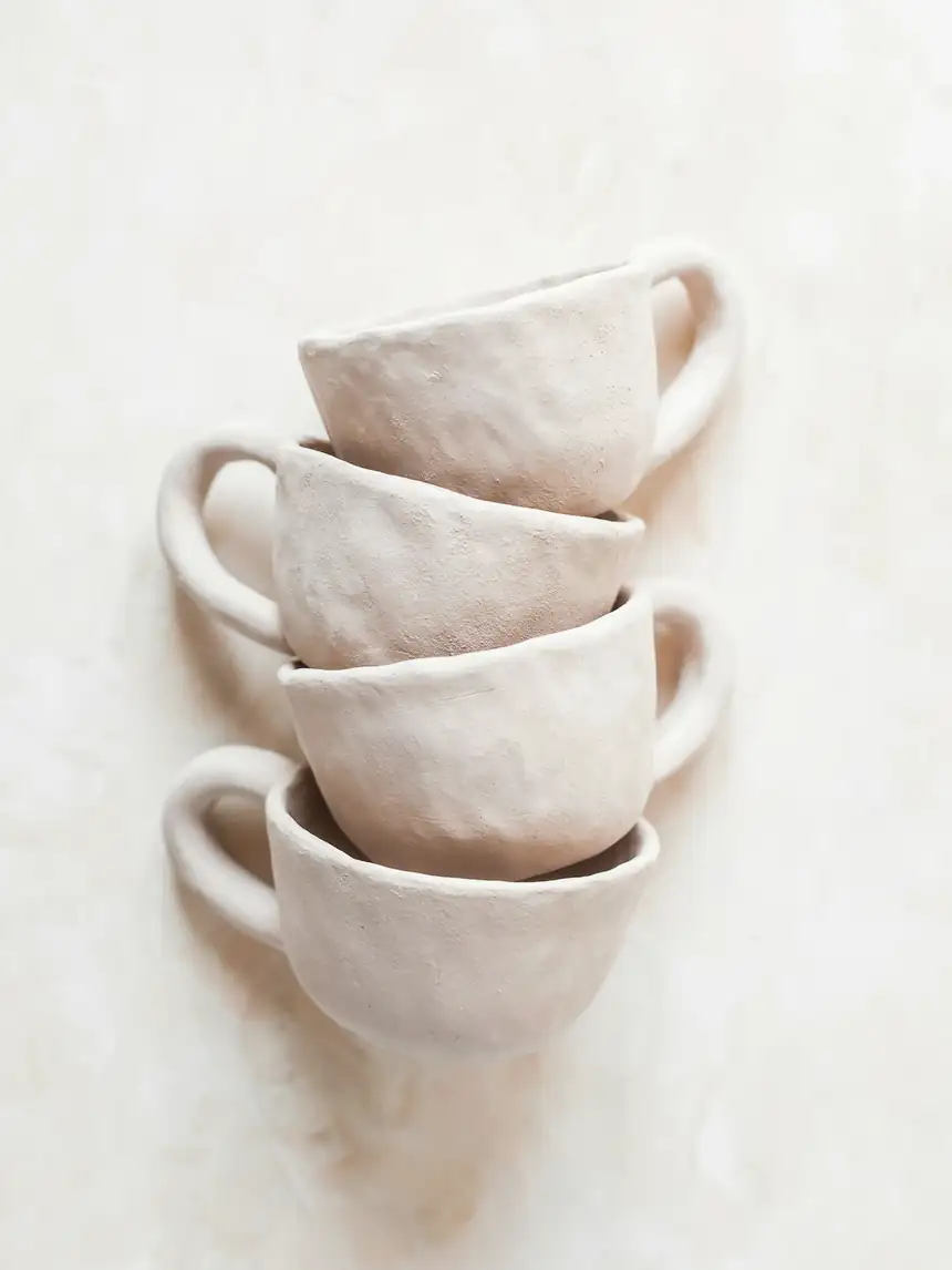 Cuatro tazas de cerámica crema apiladas