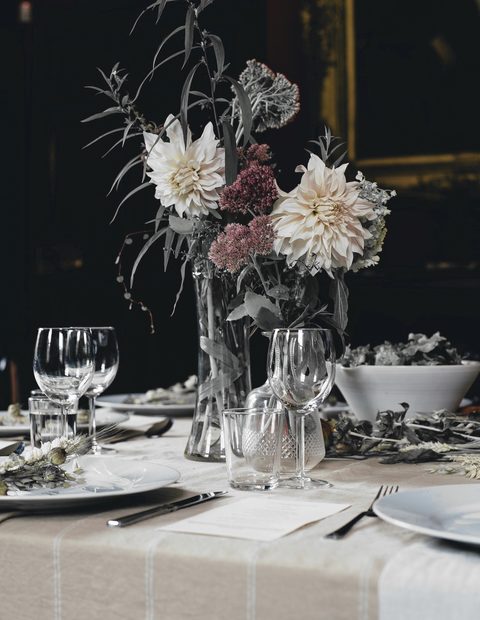 Mesa con flores, copas y un camino de mesa de lino