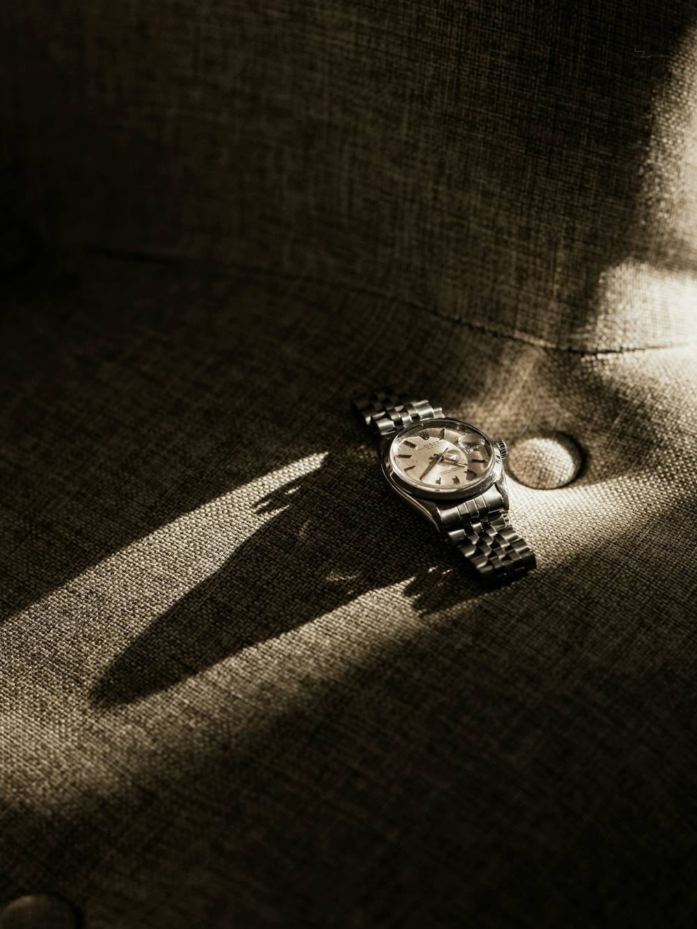 Reloj de pulsera sobre una tela, con una sombra larga
