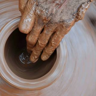 Mano de barro sobre un torno que gira, vista desde arriba