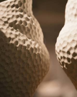 Detalle de dos jarrones con textura de panal en tono arena