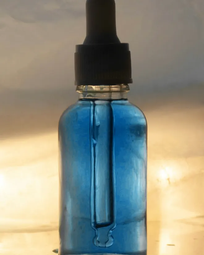 Detalle del frasco azul y su gotero negro