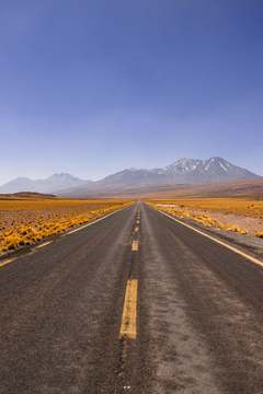 Carretera recta hacia una montaña