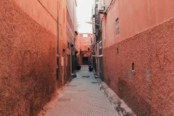 Callejón de muros rojizos que se pierde a lo lejos