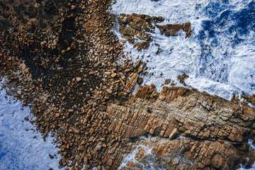 Rocas oscuras y olas turquesas vistas desde lo alto
