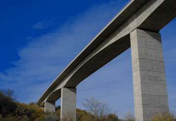 Viaducto de hormigón visto desde abajo contra el cielo azul
