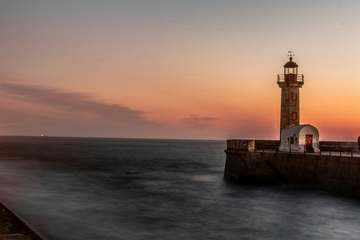 Faro de piedra sobre un cielo anaranjado