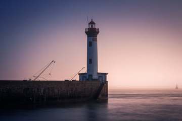 Faro blanco entre brumas rosadas