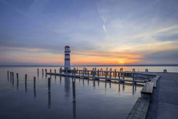 Muelle de madera y faro al crepúsculo