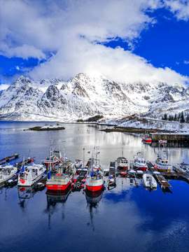 Puerto pesquero con montañas nevadas