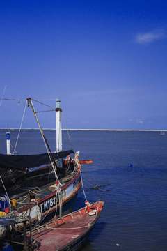 Mástil y casco de un barco bajo un cielo azul intenso