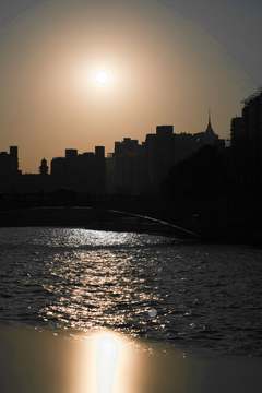 Contraluz de una ciudad y reflejos en el agua