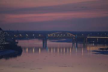 Puente iluminado sobre un río rosado