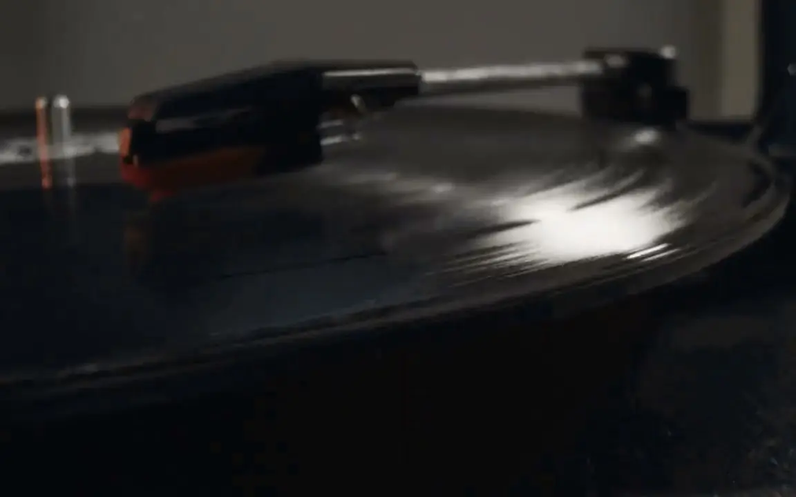 Aguja y brazo de un tocadiscos sobre un disco que gira