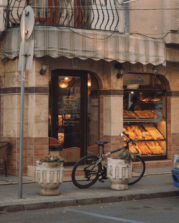La esquina de una panadería con su ventana y una bicicleta en la acera