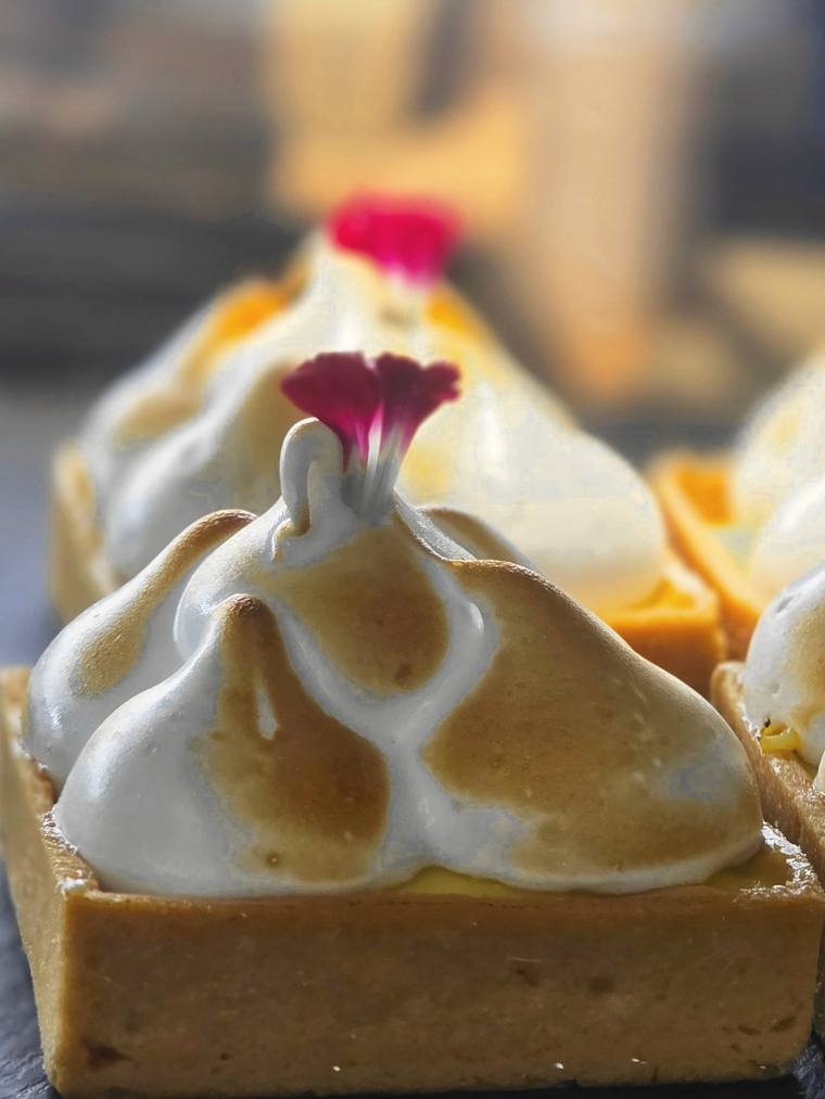 Tartaletas de limón con merengue tostado y una flor rosa