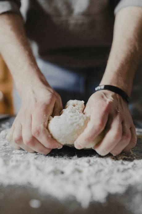 Manos amasando sobre una mesa enharinada