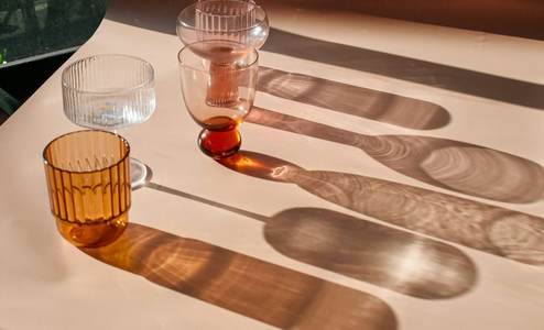 Vasos de vidrio y sus sombras largas sobre una mesa