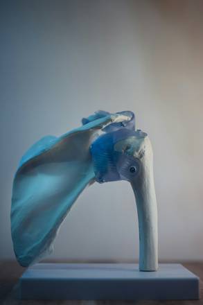 Escultura azul y blanca sobre un pedestal claro
