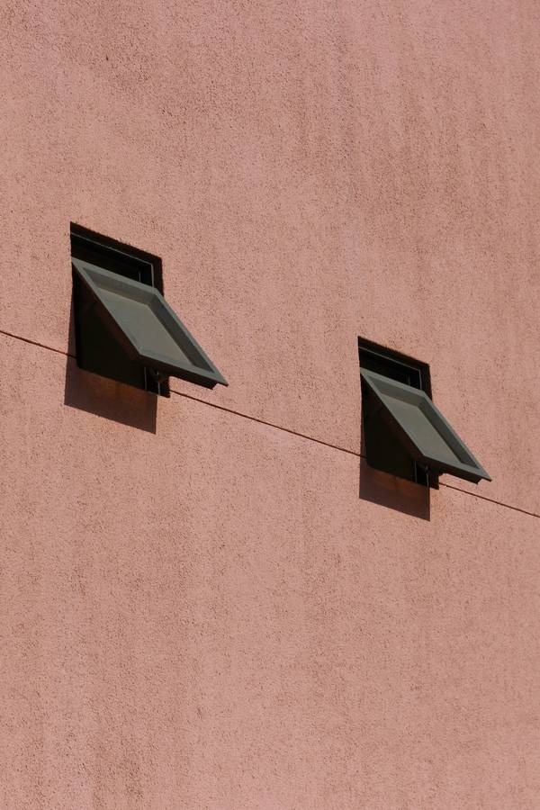 Muro rosado con dos ventanas pequeñas