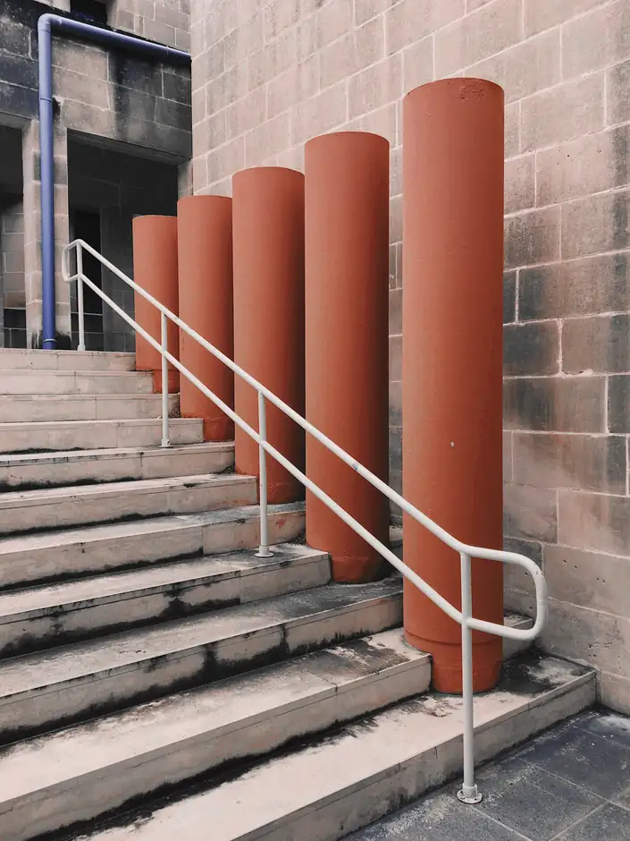 Columnas de terracota junto a una escalera con barandilla
