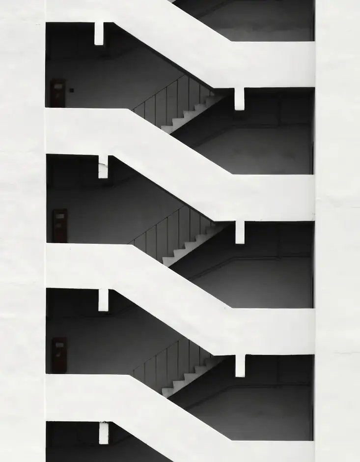 Tramos de escalera en zigzag sobre una fachada blanca
