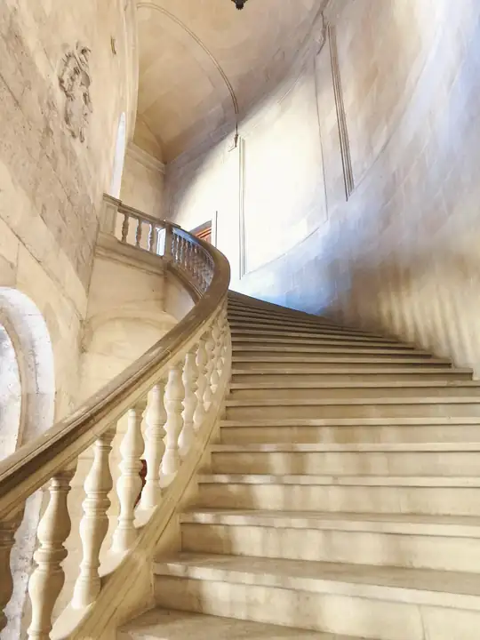Escalera de piedra con balaustrada curva y luz suave