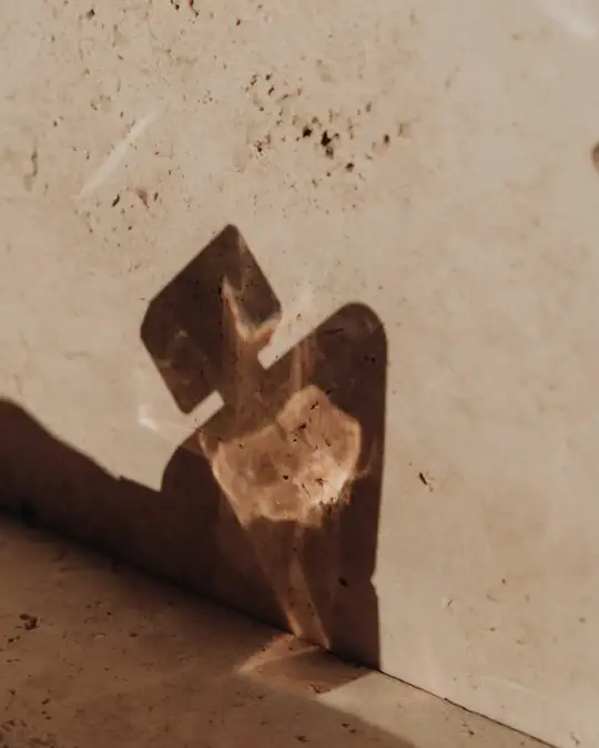Sombra de un frasco sobre una superficie de travertino