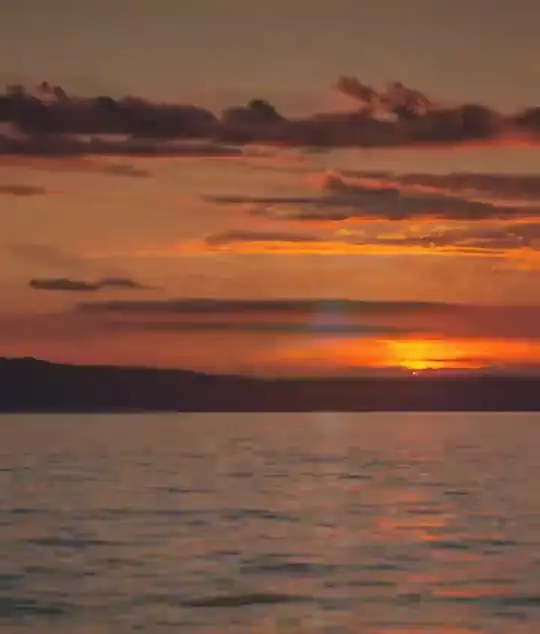 El sol sobre el agua, en una franja vertical de cielo naranja