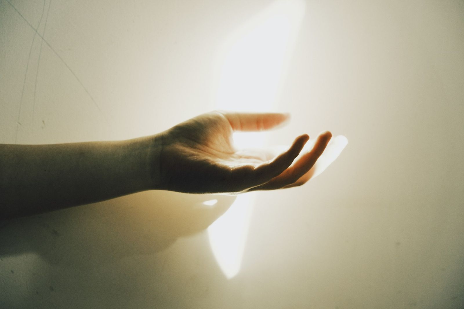 Una mano abierta hacia la luz