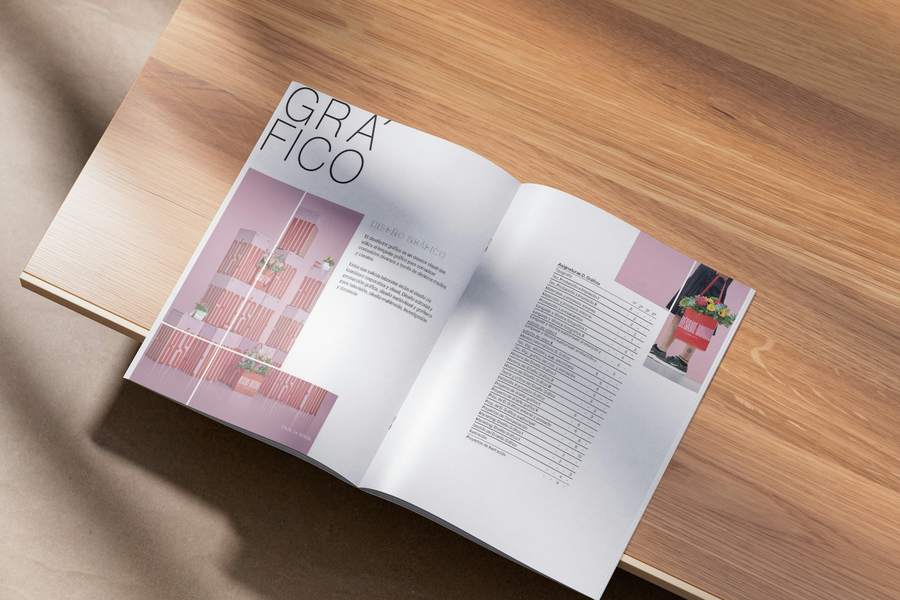 Revista abierta sobre una mesa de madera, con títulos grandes y una grilla de imágenes