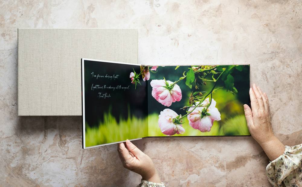 Manos hojeando un álbum de fotografías de flores