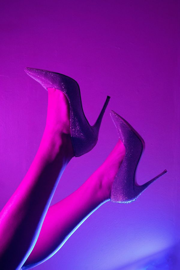 Tacones brillantes bajo una luz violeta y magenta