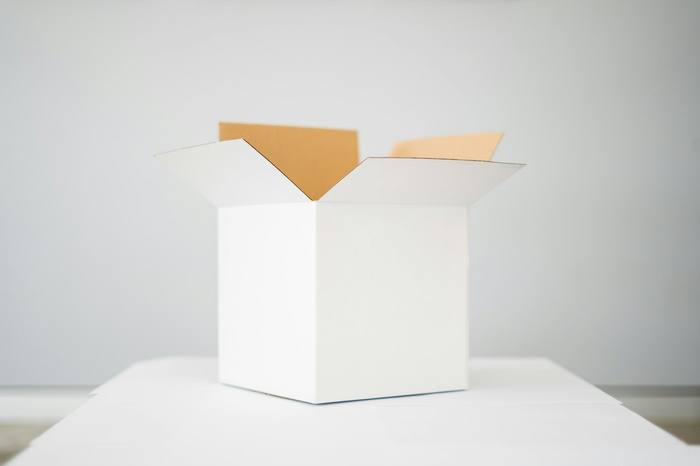Caja blanca abierta sobre una mesa clara