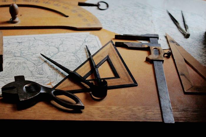 Reglas, compás y tijeras sobre un plano de dibujo
