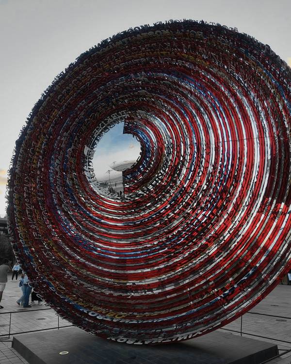 Escultura circular en espiral con cintas rojas