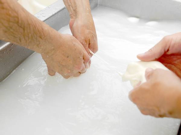 Manos trabajando pulpa blanca de papel