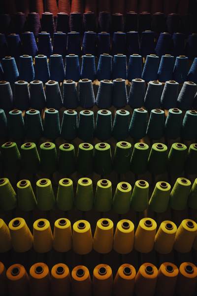 Filas de conos de hilo de colores oscuros
