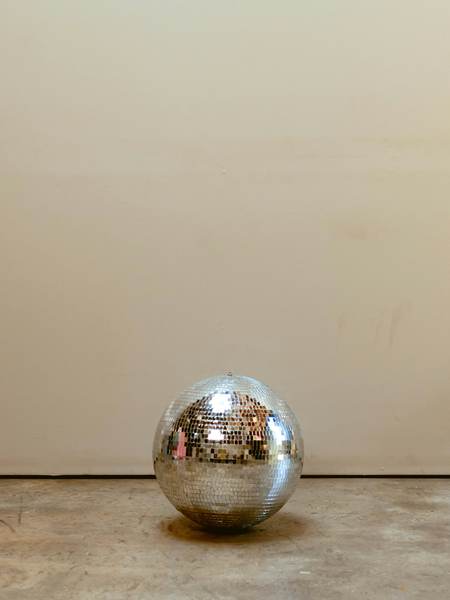 Bola de espejos sobre el suelo de una sala vacía