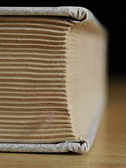 Lomo de un libro grueso con sus pliegos cosidos