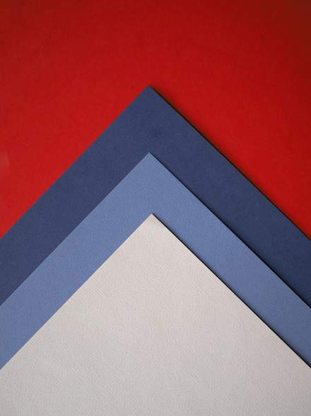 Cartulinas roja, azul y gris dobladas en ángulo