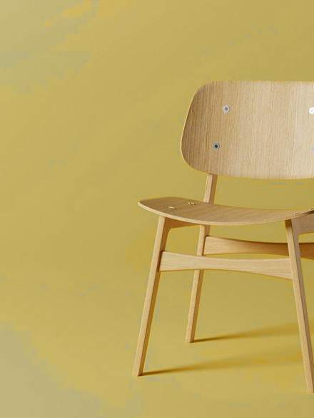 Silla de madera clara sobre un fondo amarillo