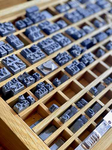 Caja de imprenta con tipos azules en casilleros de madera