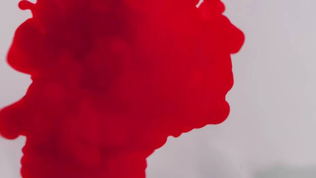 Tinta roja que se abre en agua clara