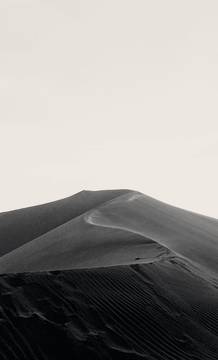 Una duna en blanco y negro bajo un cielo claro