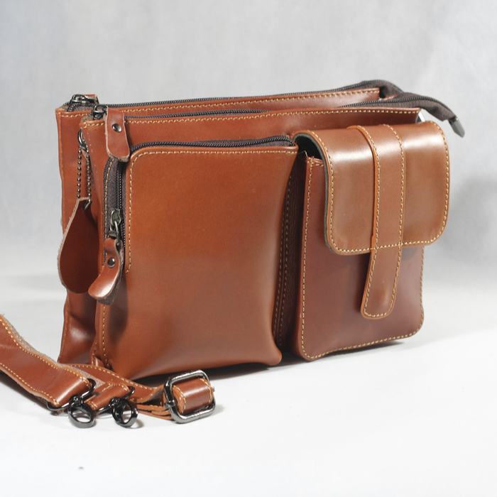 Bolso de cuero café oscuro con una correa corta, sobre un fondo blanco