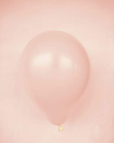 Un globo color durazno sobre fondo del mismo tono