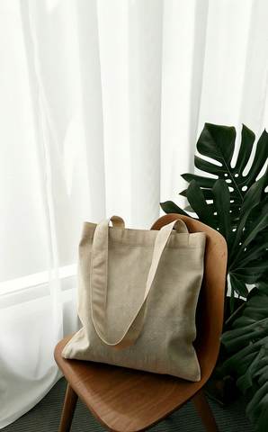 Bolsa de tela sobre una silla junto a una ventana