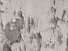 Capas de pintura blanca que se desprenden de una superficie