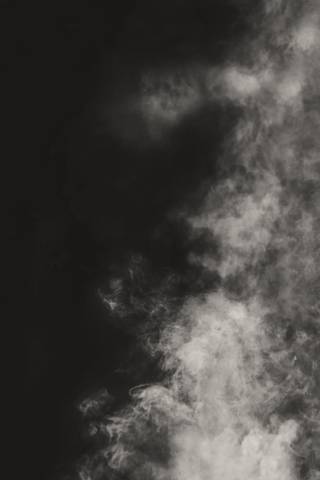 Humo gris que sube sobre un fondo oscuro